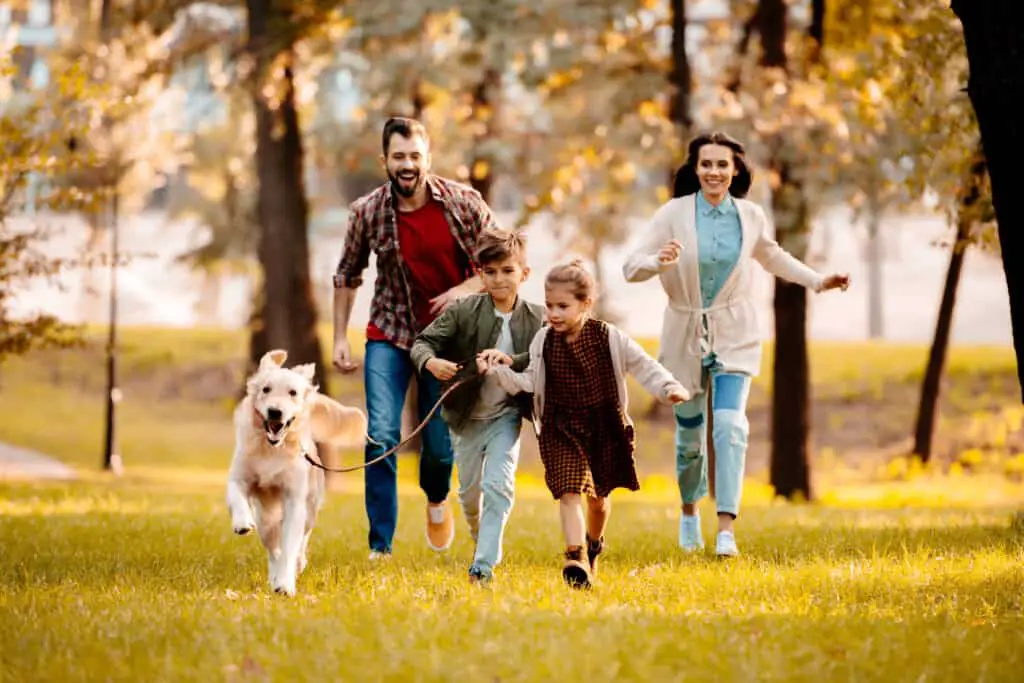 National Walk Your Dog Week Family Walking dog in park