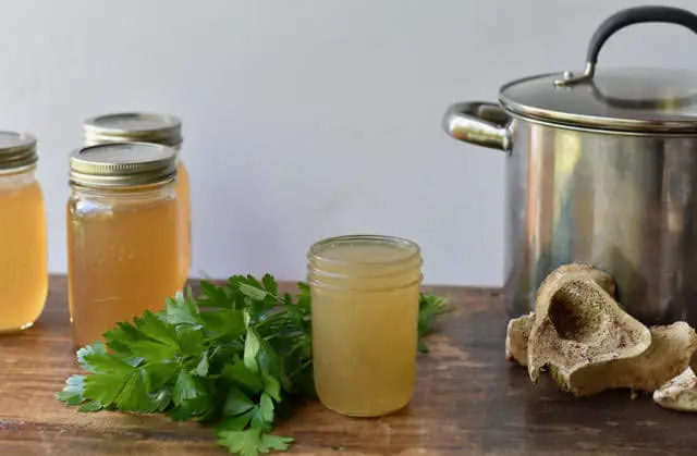 Bone broth in jars, stock pot, hollow marrow bone