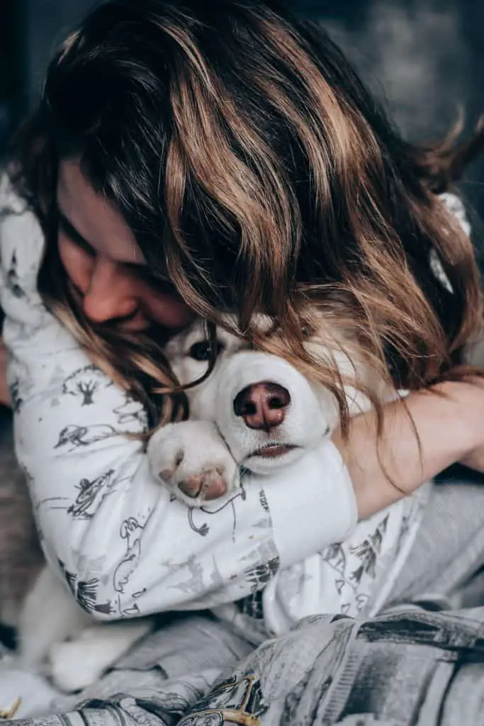 Benefits of owning a dog girl in pajamas snuggling with dog