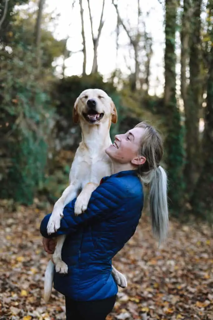 Woman holding dog like a baby and the dog looks happy about it