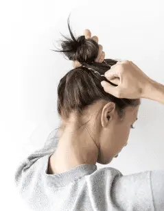 Best Dog Nail Grinders woman putting hair up in bun