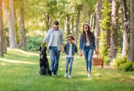 Black German Shepherd with family walking in park
