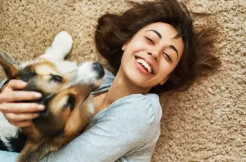 Do Corgis Shed Girl lying on carpet with Corgi